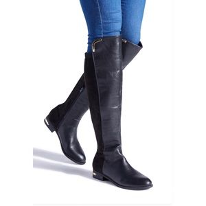 Knee high black boots with gold accents.